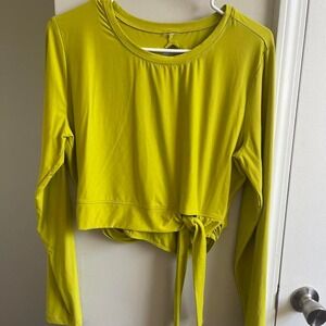 Green long sleeve athletic shirt with tie detail in front and an open back